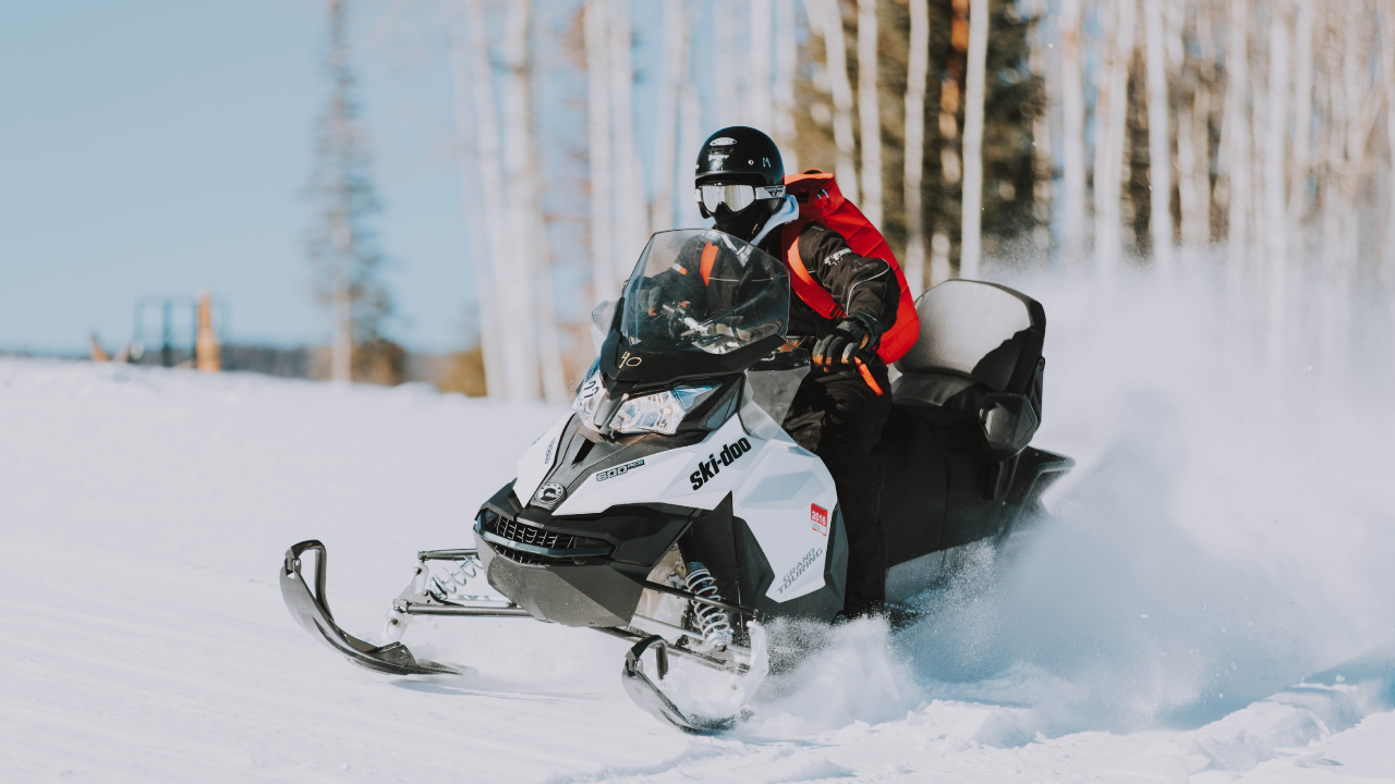Person Riding Black and White Snow Mobile. Wallpaper in 1280x720 Resolution
