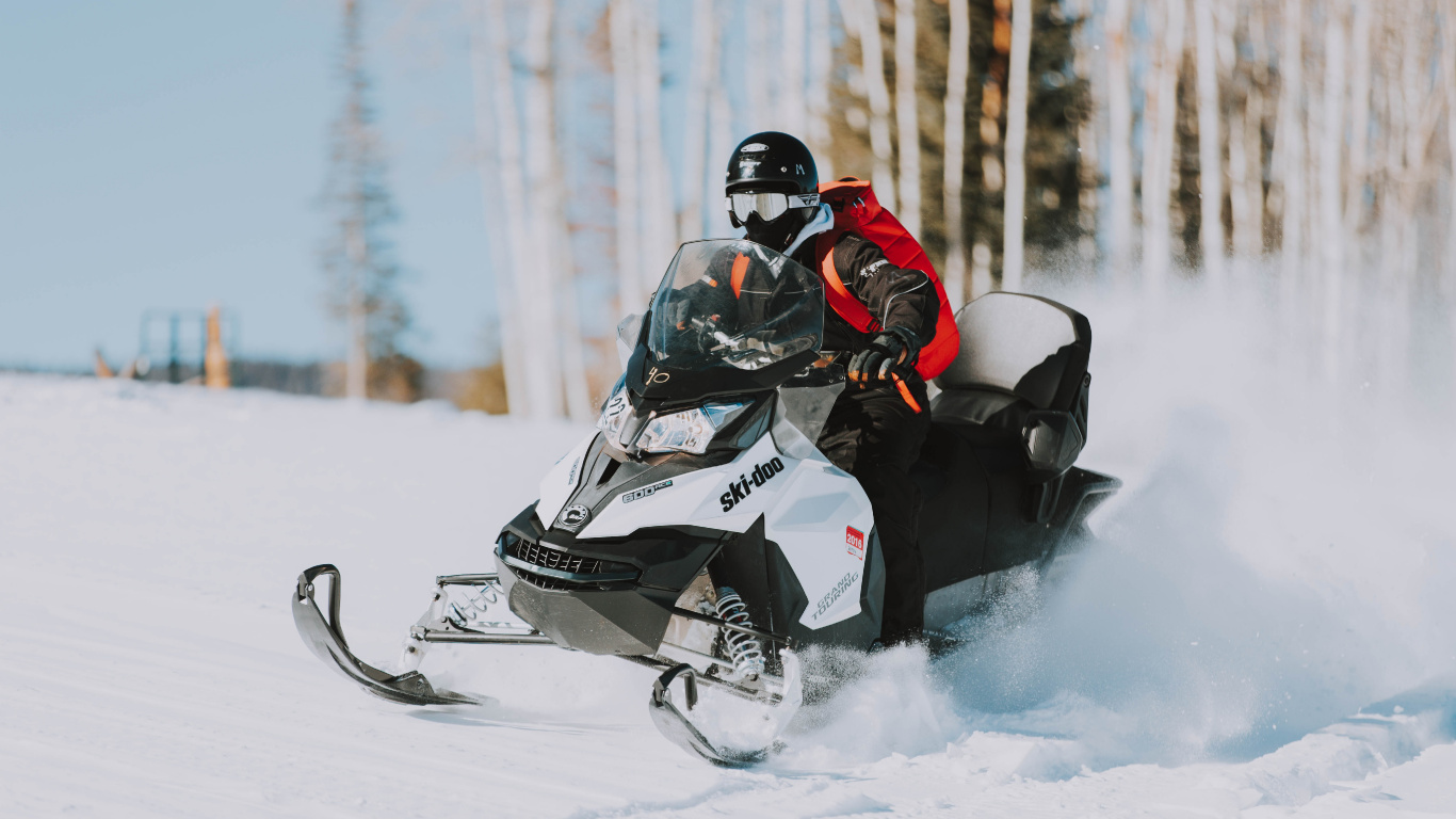 Person Riding Black and White Snow Mobile. Wallpaper in 1366x768 Resolution