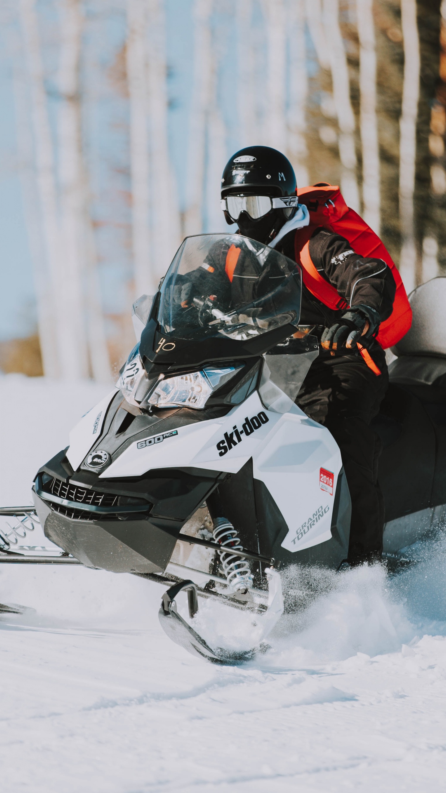 Person Riding Black and White Snow Mobile. Wallpaper in 1440x2560 Resolution