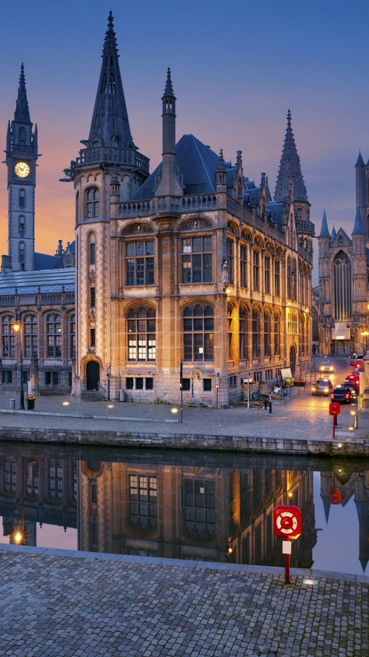 Edificio de Hormigón Marrón Cerca Del Cuerpo de Agua Durante la Noche. Wallpaper in 750x1334 Resolution