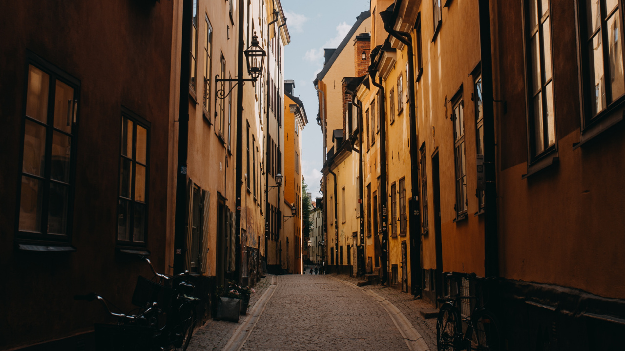 Route Vide Entre Les Bâtiments en Béton Brun Pendant la Journée. Wallpaper in 1280x720 Resolution