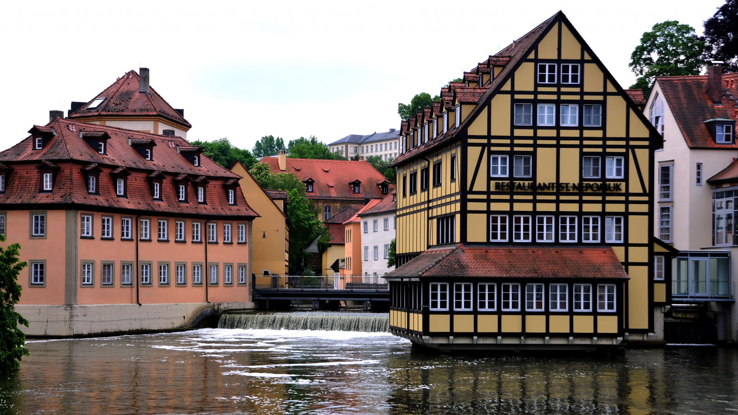 Braunes Und Beiges Betongebäude am Fluss Tagsüber. Wallpaper in 2560x1440 Resolution