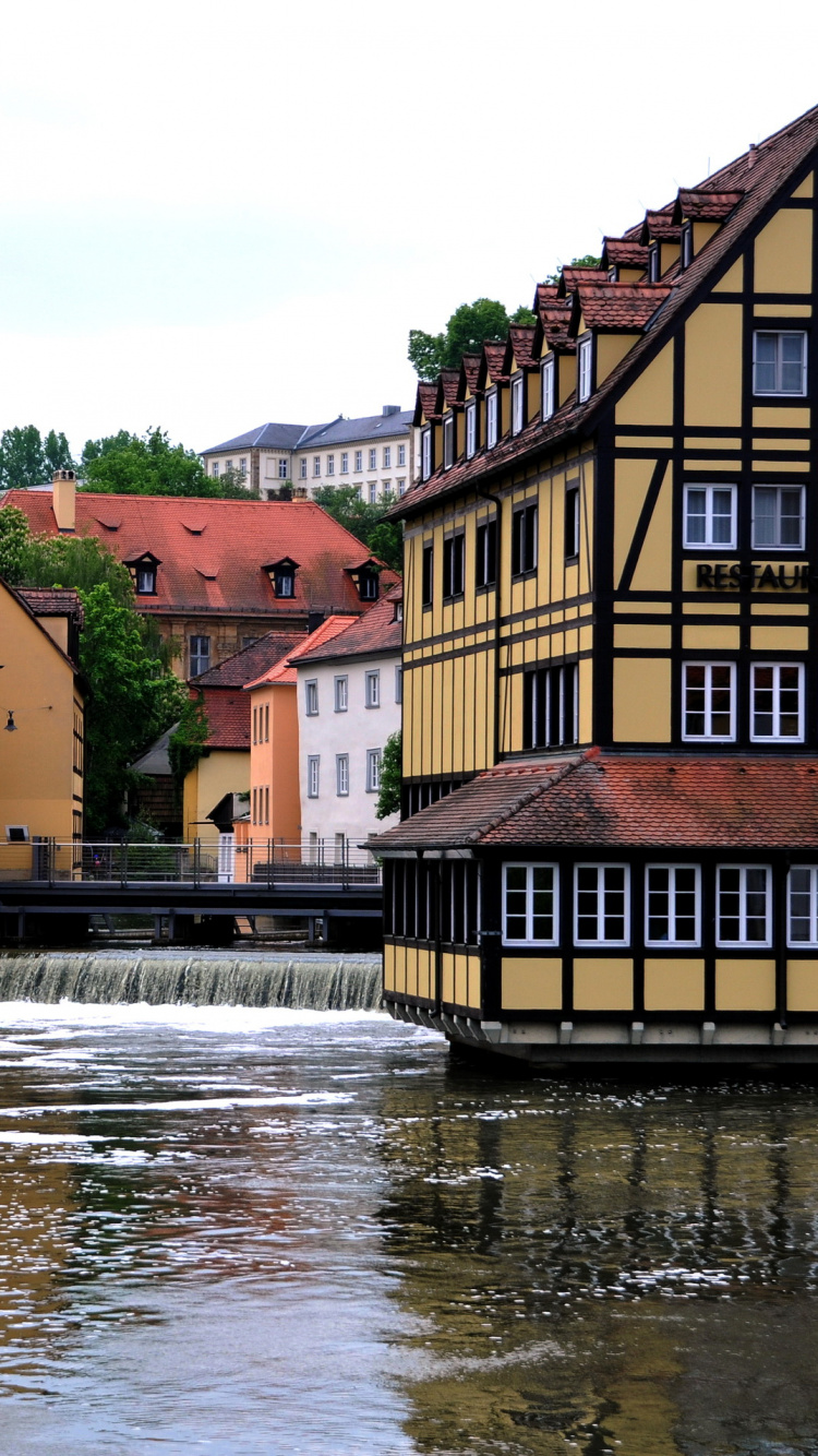 Braunes Und Beiges Betongebäude am Fluss Tagsüber. Wallpaper in 750x1334 Resolution