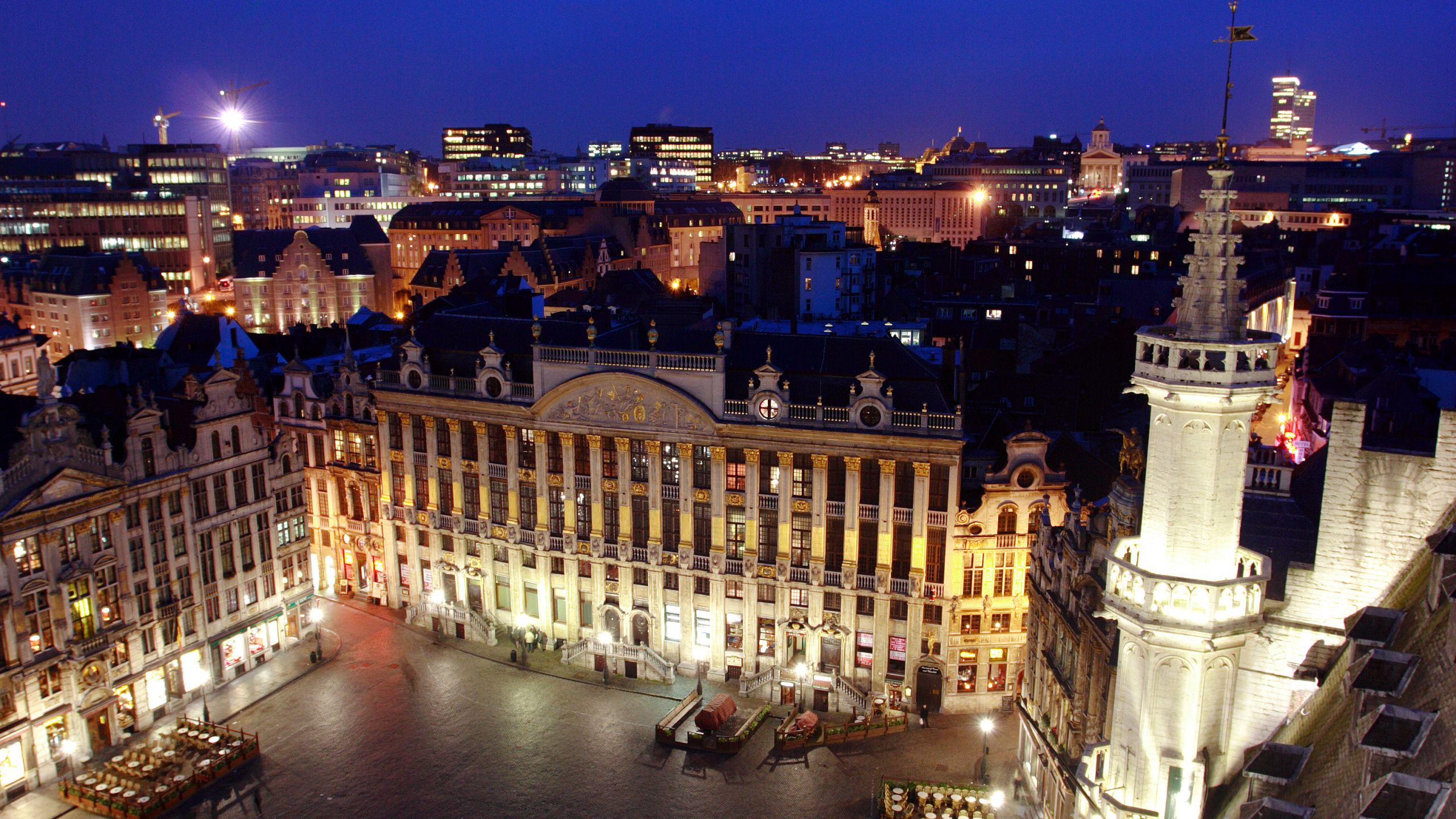 Gente Caminando en la Calle Cerca Del Edificio Durante la Noche. Wallpaper in 2560x1440 Resolution