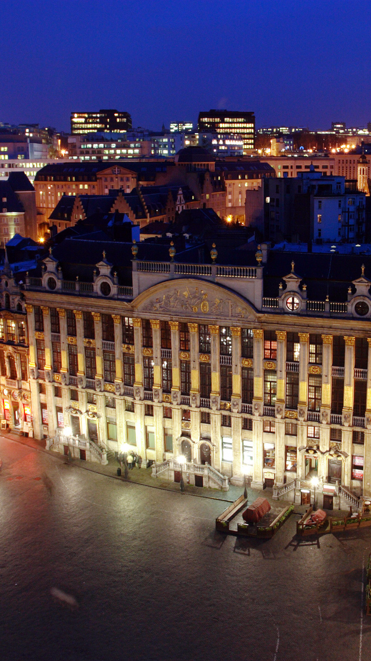 Gente Caminando en la Calle Cerca Del Edificio Durante la Noche. Wallpaper in 750x1334 Resolution