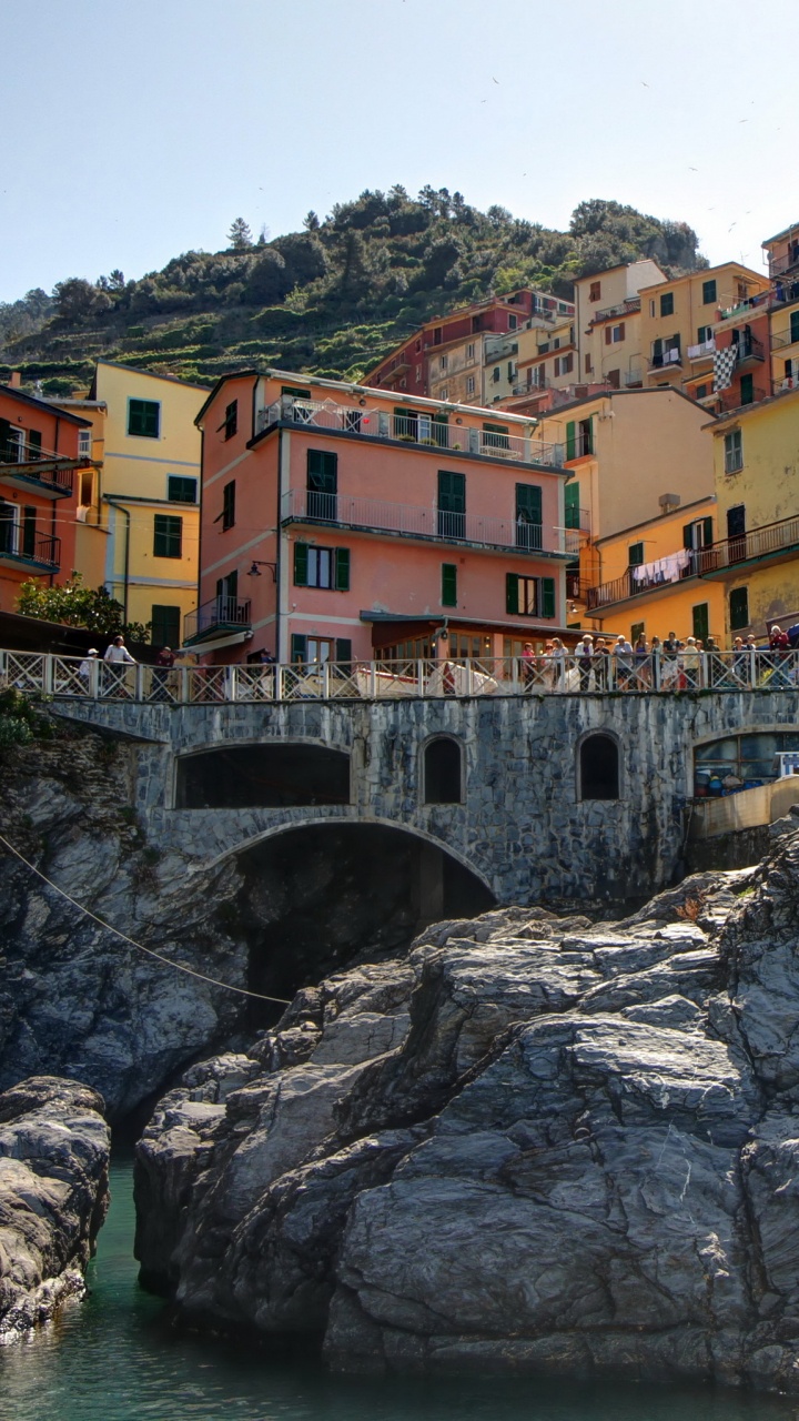 Bâtiments en Béton Marron et Blanc Près D'un Plan D'eau Pendant la Journée. Wallpaper in 720x1280 Resolution