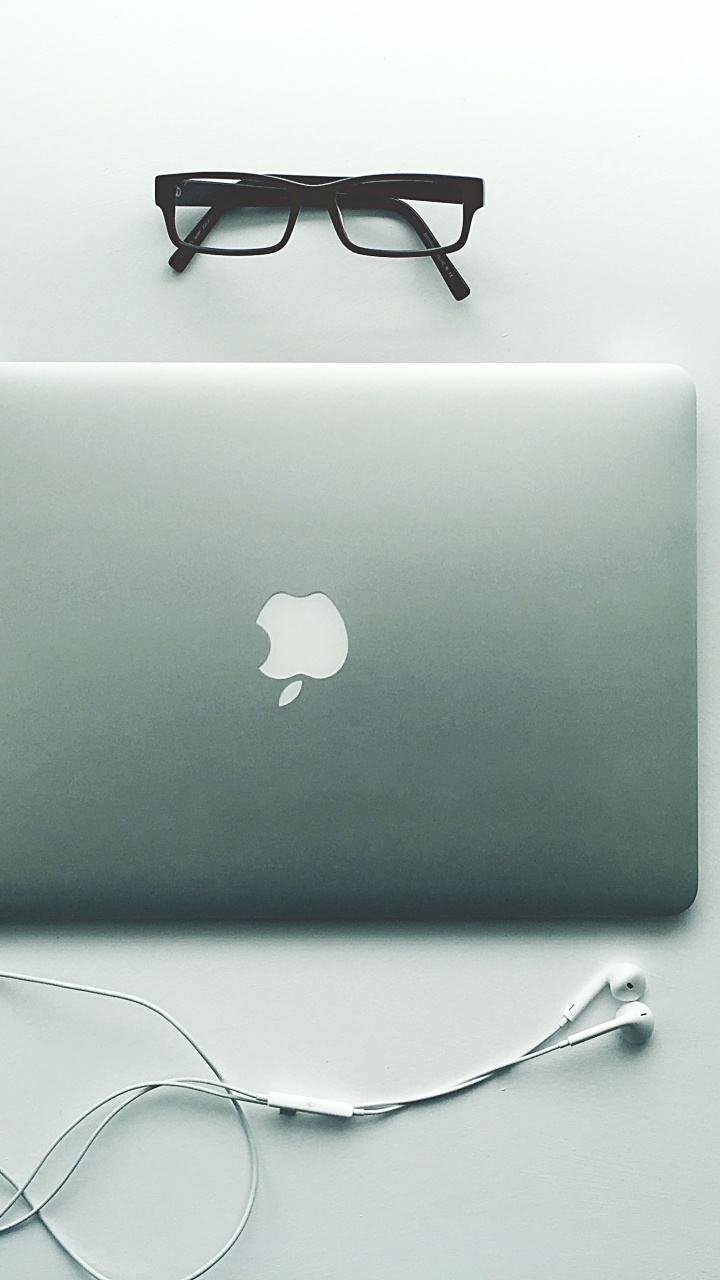 Silbernes MacBook Neben Schwarz Gerahmter Brille. Wallpaper in 720x1280 Resolution