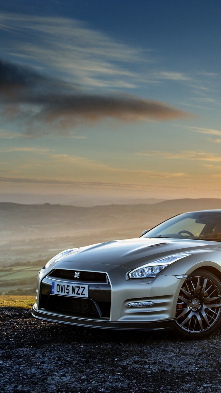 Schwarzer Audi r 8 Auf Braunem Feld Bei Sonnenuntergang. Wallpaper in 720x1280 Resolution