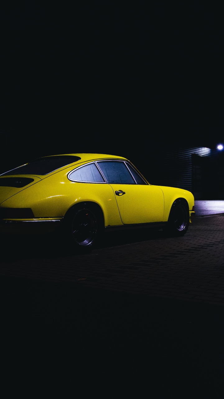 Coupé Jaune Sur Route Goudronnée Noire Pendant la Nuit. Wallpaper in 720x1280 Resolution