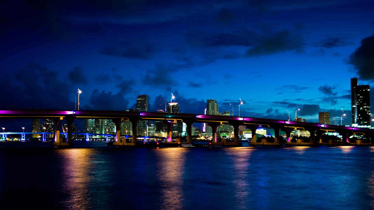 Green and Brown Concrete Building Near Body of Water During Night Time. Wallpaper in 1280x720 Resolution