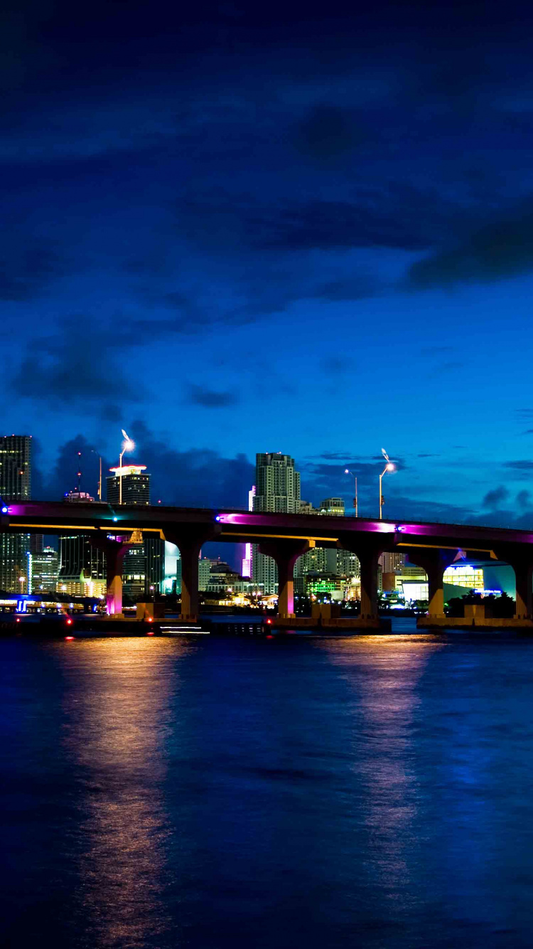 Edificio de Hormigón Verde y Marrón Cerca Del Cuerpo de Agua Durante la Noche. Wallpaper in 750x1334 Resolution