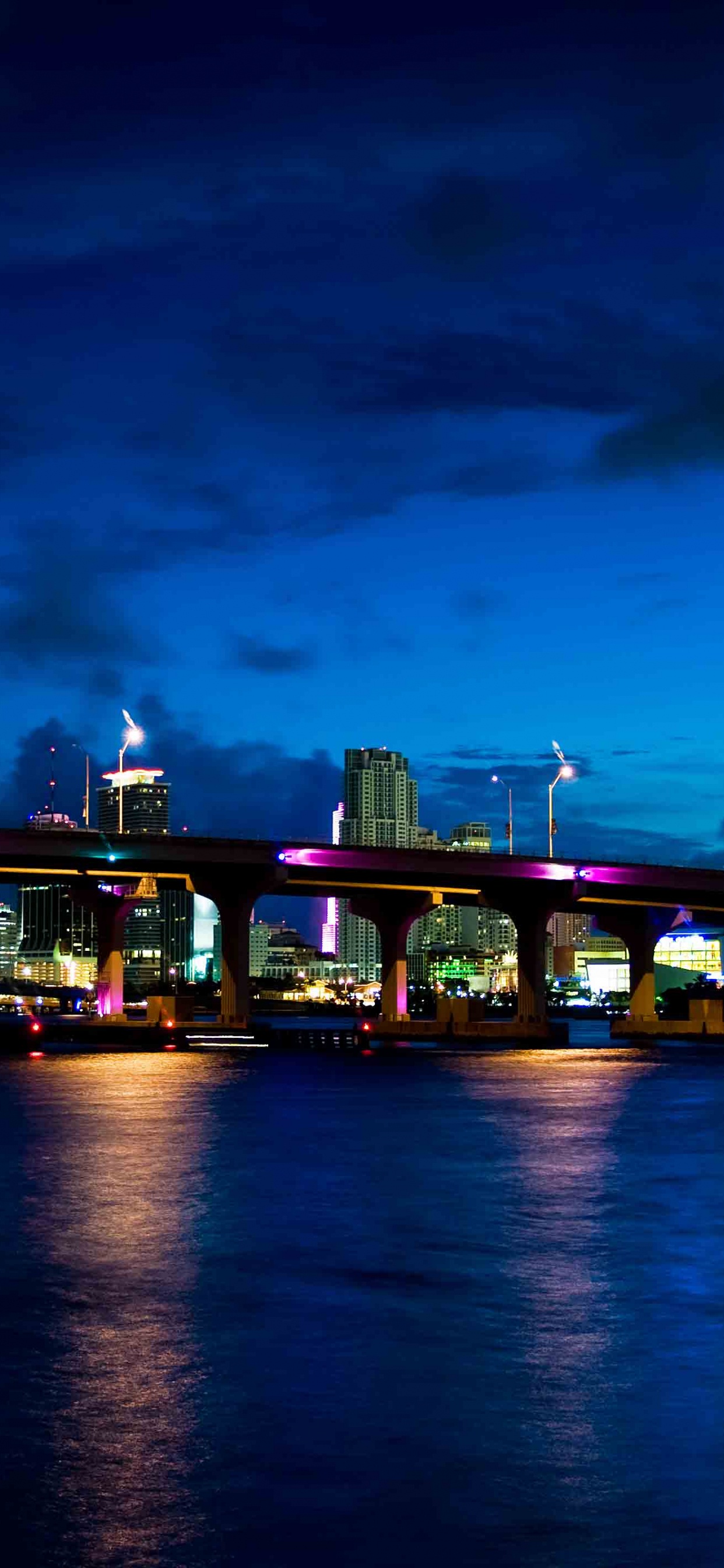 Bâtiment en Béton Vert et Marron Près D'un Plan D'eau Pendant la Nuit. Wallpaper in 1242x2688 Resolution