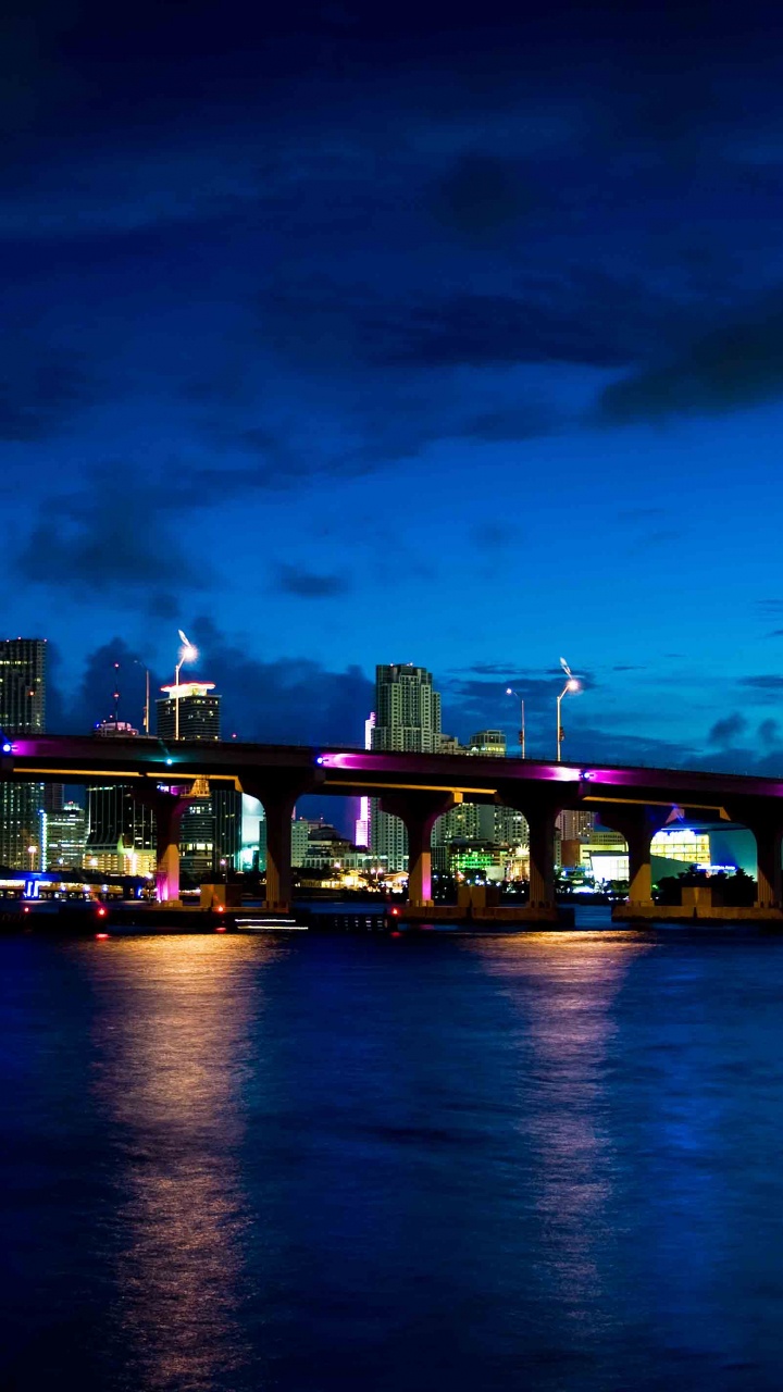 Bâtiment en Béton Vert et Marron Près D'un Plan D'eau Pendant la Nuit. Wallpaper in 720x1280 Resolution