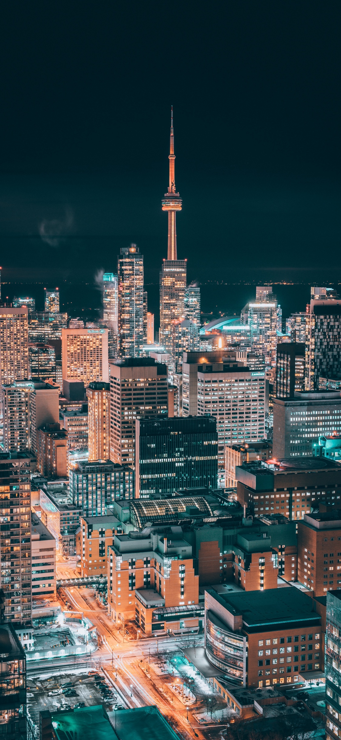 Stadt Mit Hochhäusern Während Der Nacht. Wallpaper in 1125x2436 Resolution