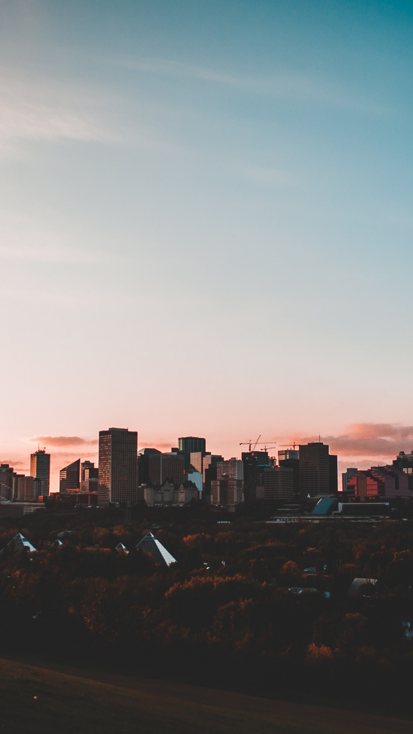 Skyline Der Stadt Unter Blauem Himmel Bei Sonnenuntergang. Wallpaper in 1440x2560 Resolution