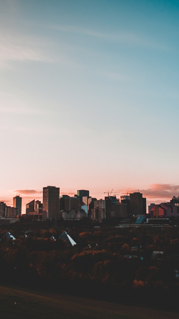Skyline Der Stadt Unter Blauem Himmel Bei Sonnenuntergang. Wallpaper in 720x1280 Resolution