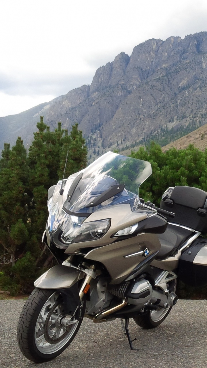Black and Silver Motorcycle Parked on Brown Dirt Road Near Green Trees and Mountain During Daytime. Wallpaper in 720x1280 Resolution