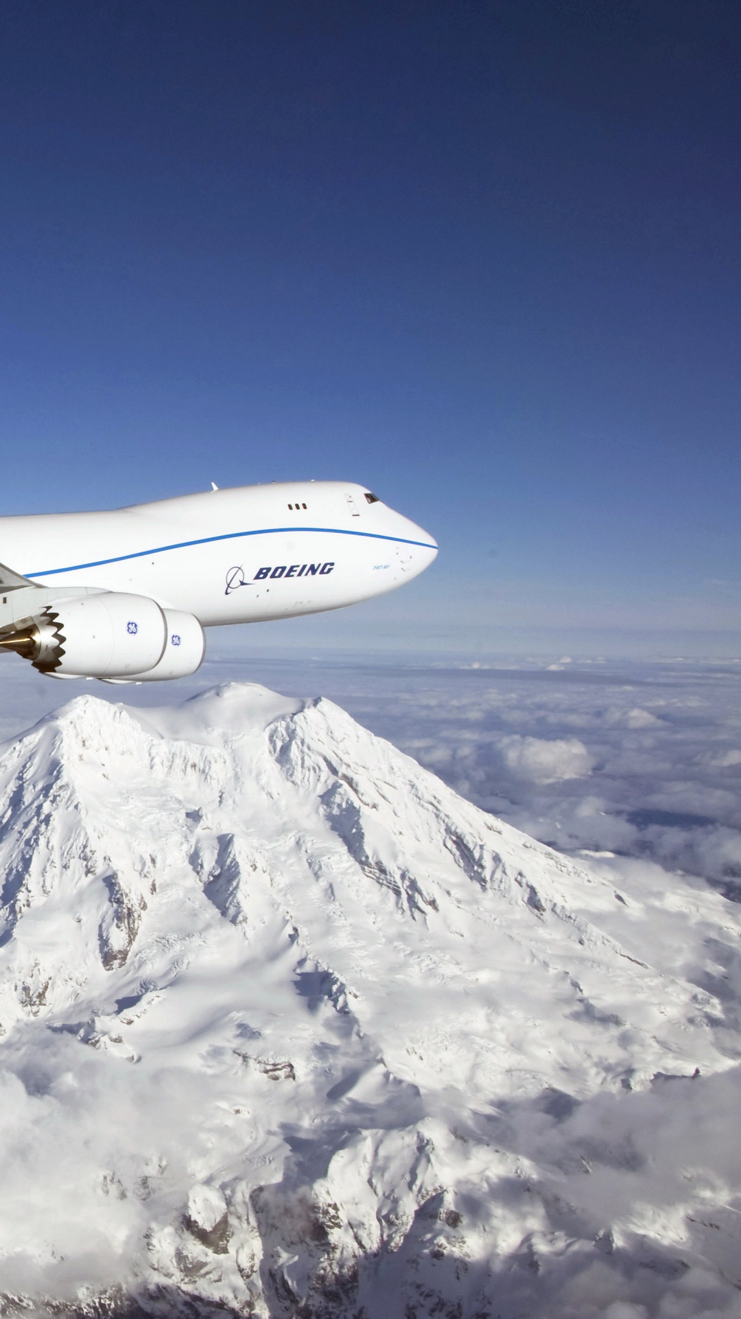 Avión Blanco y Azul Sobrevolando Montañas Cubiertas de Nieve Durante el Día. Wallpaper in 1080x1920 Resolution