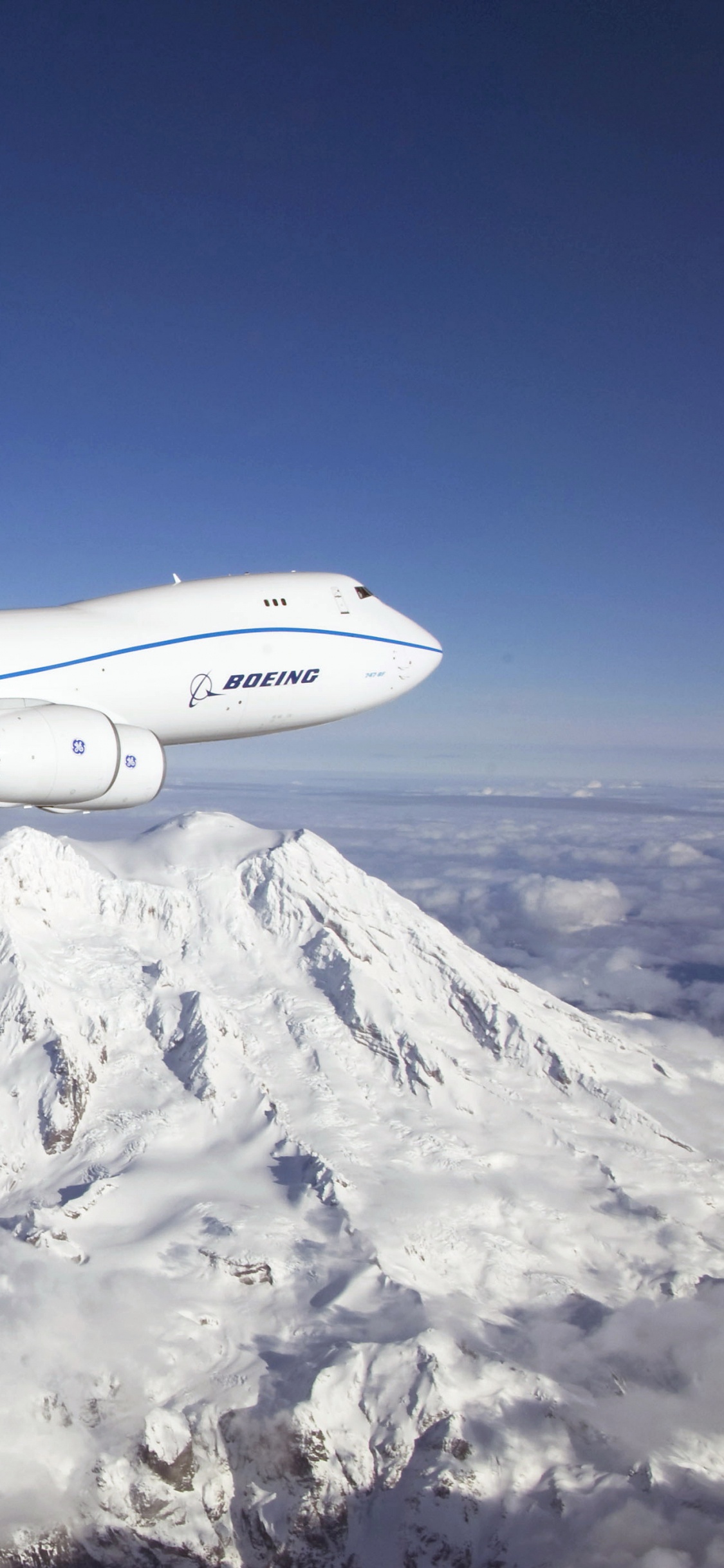 Weißes Und Blaues Flugzeug, Das Tagsüber Über Schneebedeckte Berge Fliegt. Wallpaper in 1125x2436 Resolution