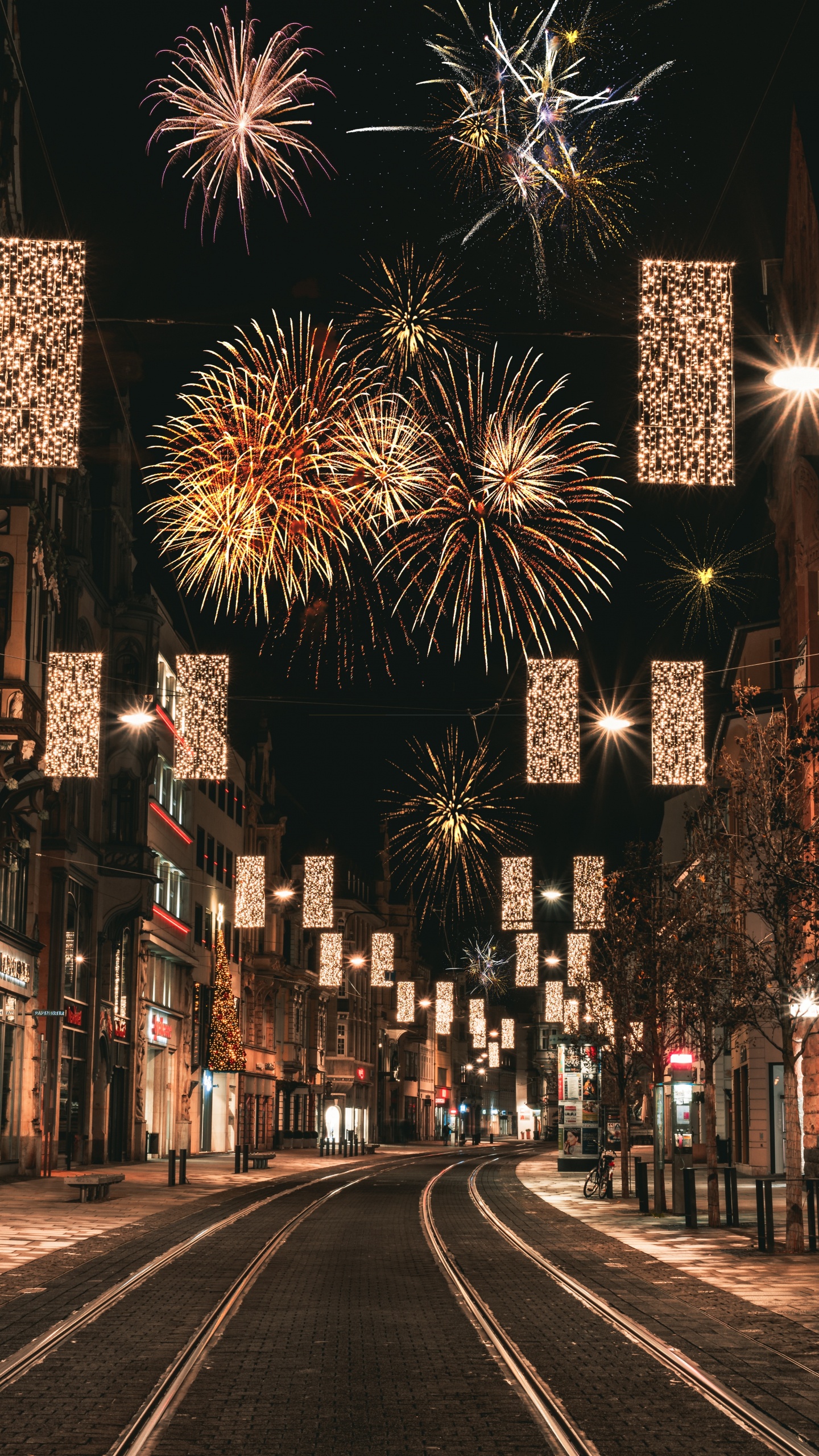 Leute, Die Nachts Auf Der Straße Mit Feuerwerk Gehen. Wallpaper in 1440x2560 Resolution