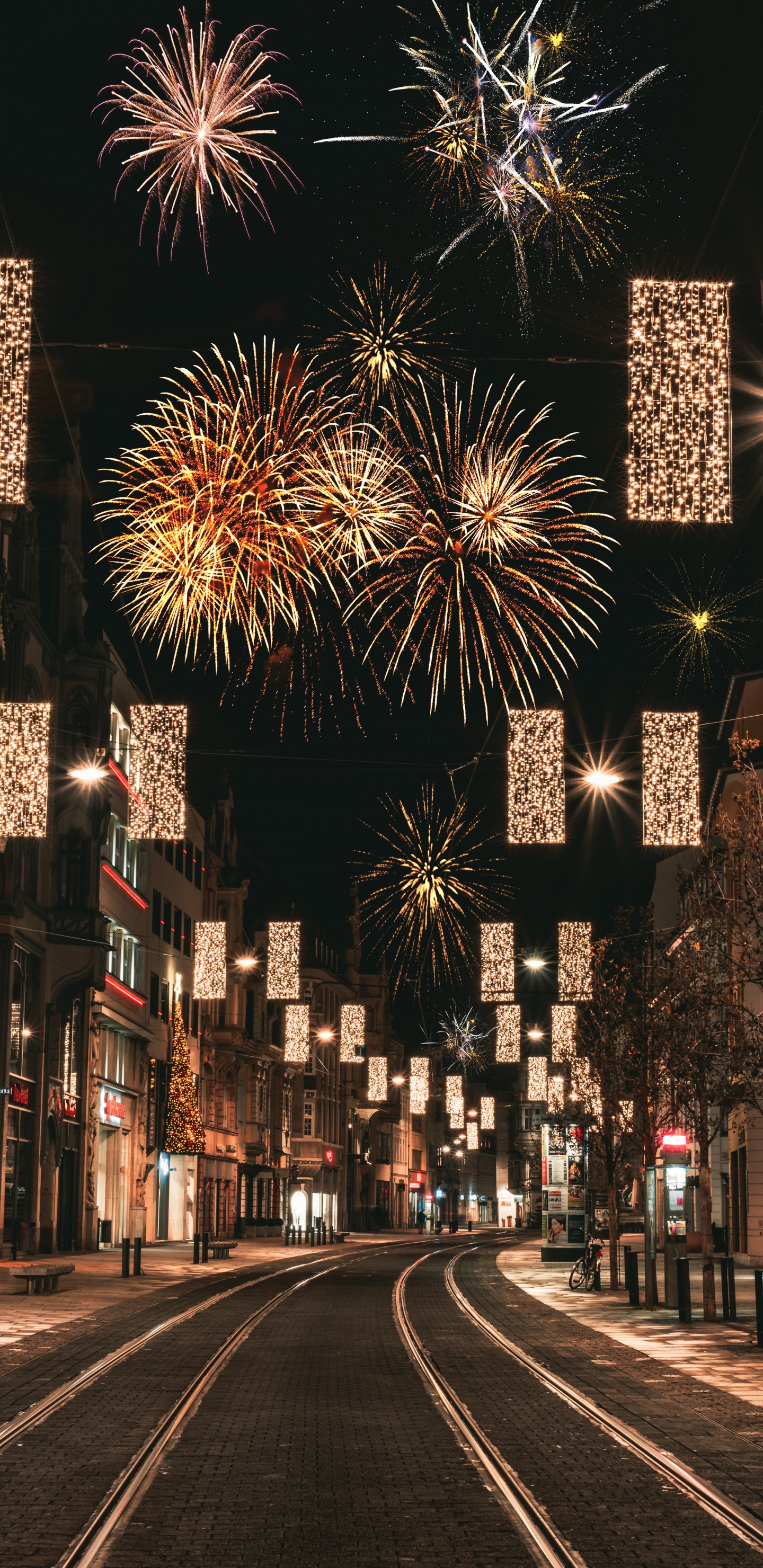 Leute, Die Nachts Auf Der Straße Mit Feuerwerk Gehen. Wallpaper in 1440x2960 Resolution