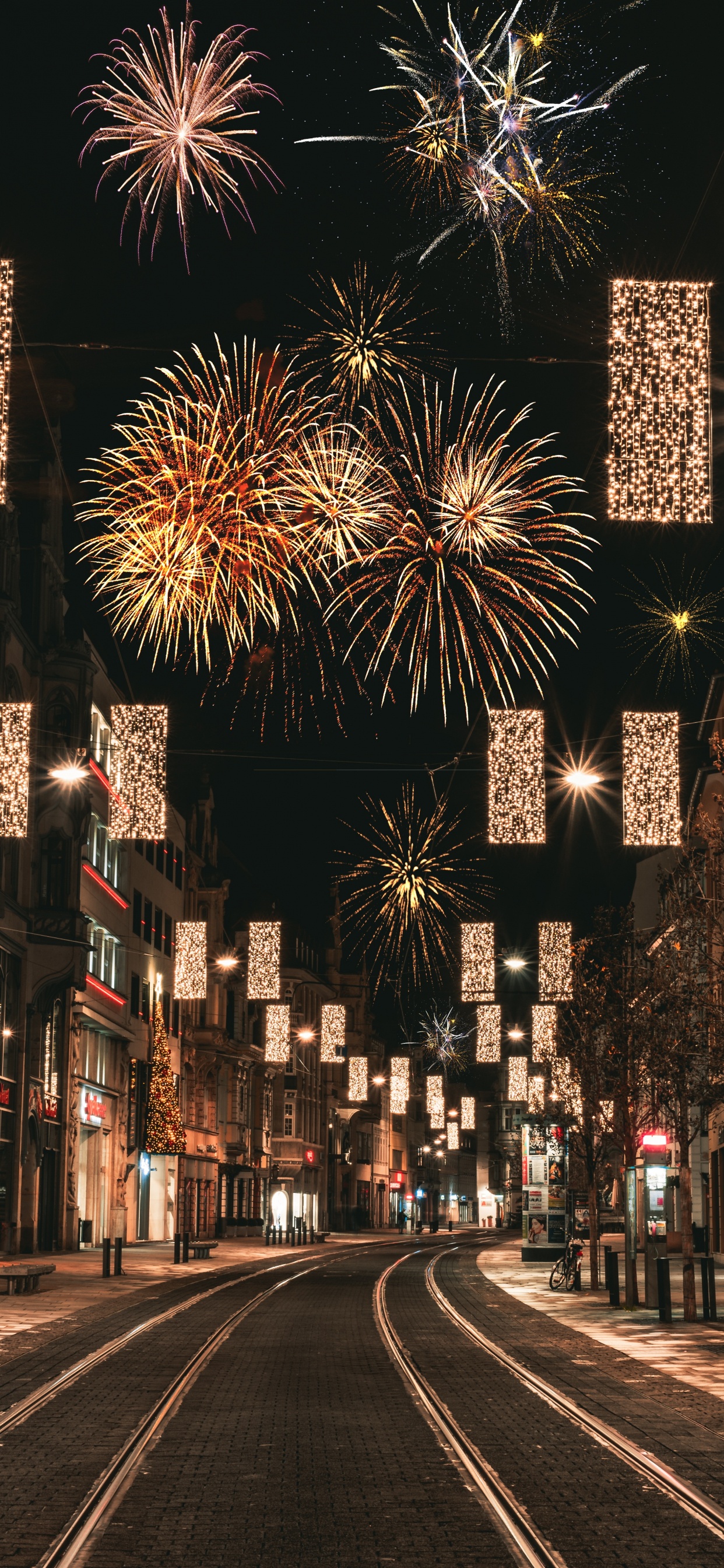 People Walking on Street With Fireworks Display During Night Time. Wallpaper in 1242x2688 Resolution