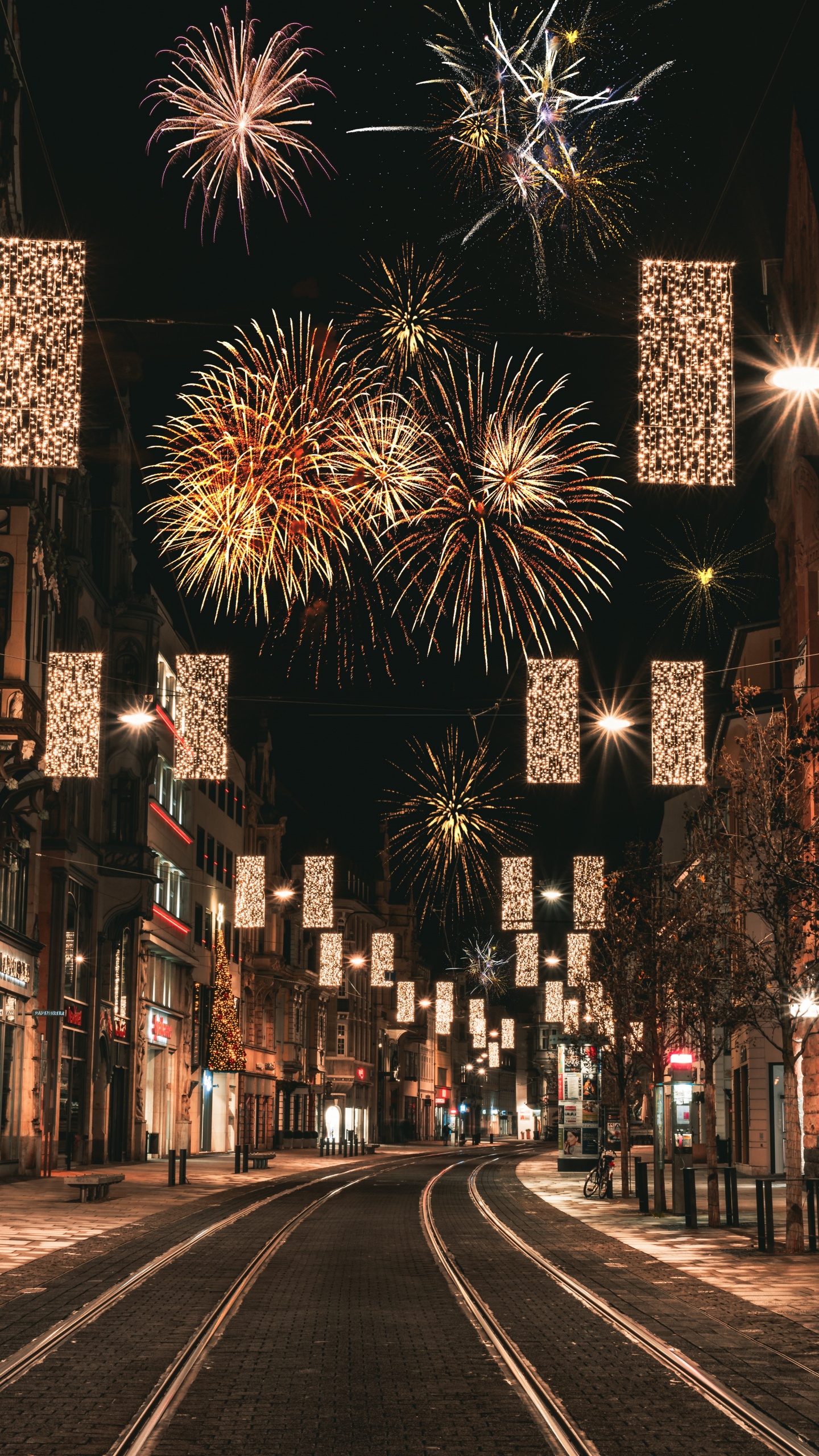 People Walking on Street With Fireworks Display During Night Time. Wallpaper in 1440x2560 Resolution