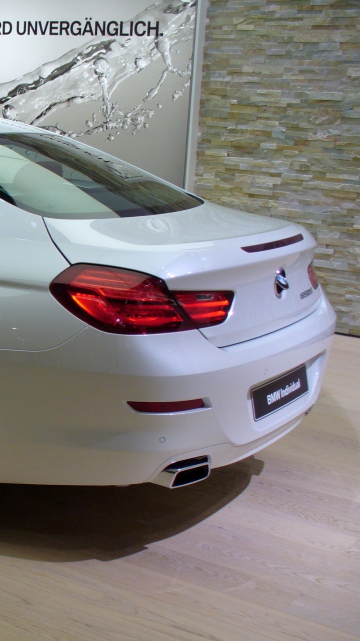 Sedán Blanco Sobre Pavimento Gris. Wallpaper in 720x1280 Resolution