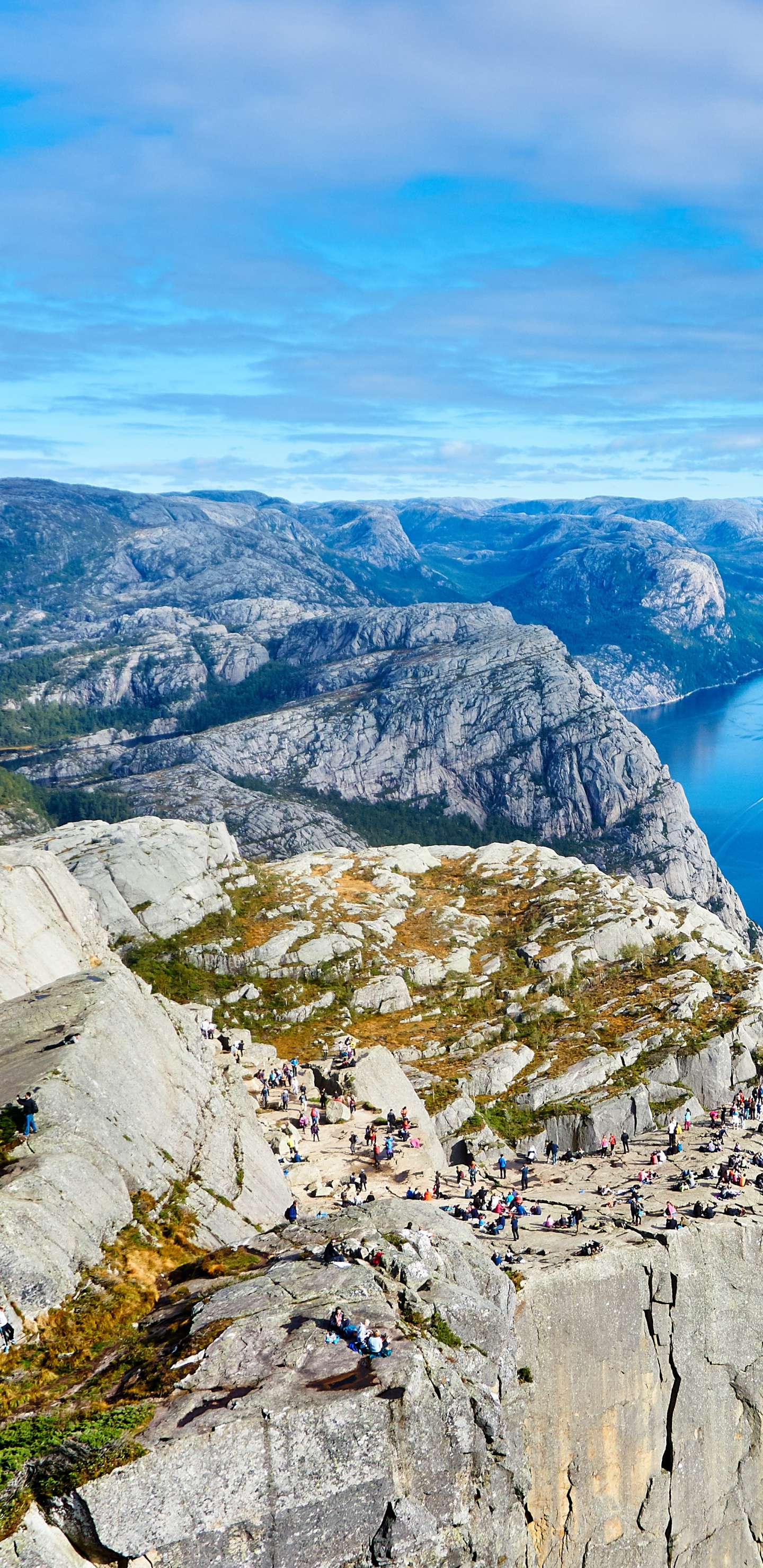 Blue Lake Between Gray Rocky Mountains Under Blue and White Sunny Cloudy Sky During Daytime. Wallpaper in 1440x2960 Resolution