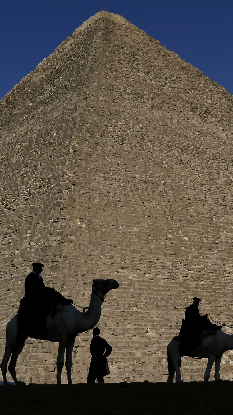 Group of People Riding Camels on Brown Sand Near Pyramid Under Blue Sky During Daytime. Wallpaper in 750x1334 Resolution