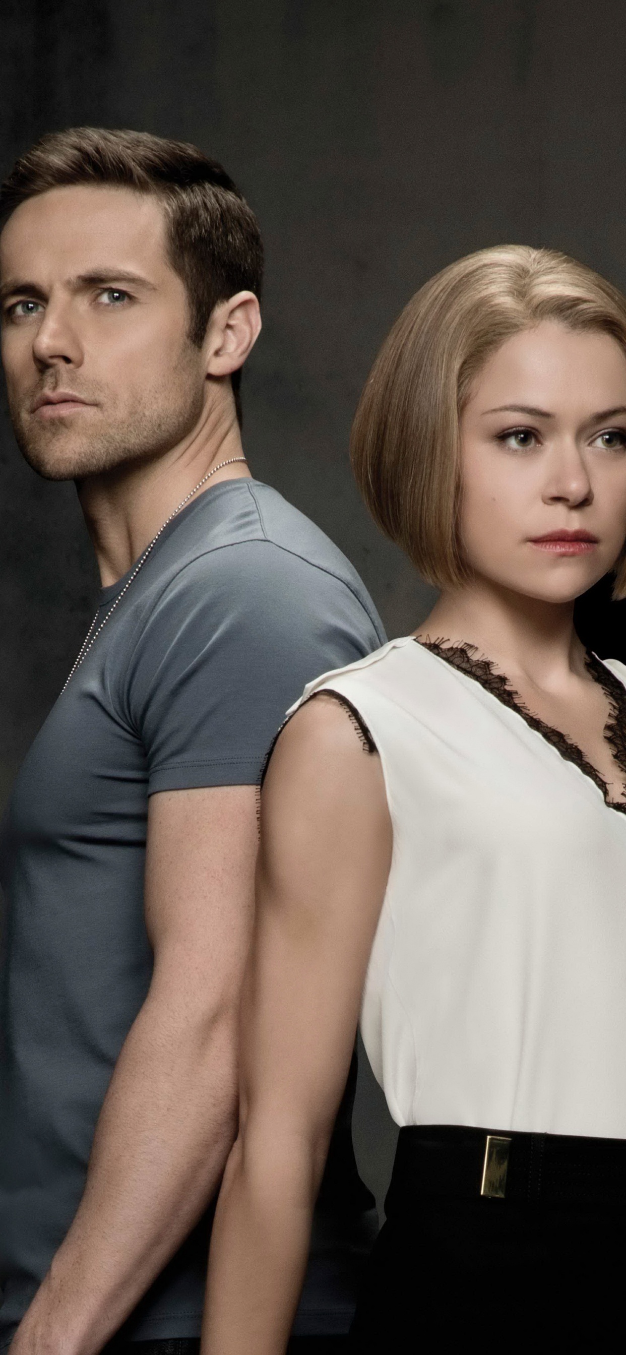 Hombre Con Chaleco Negro de Pie Junto a Una Mujer Con Camisa Blanca Sin Mangas. Wallpaper in 1242x2688 Resolution