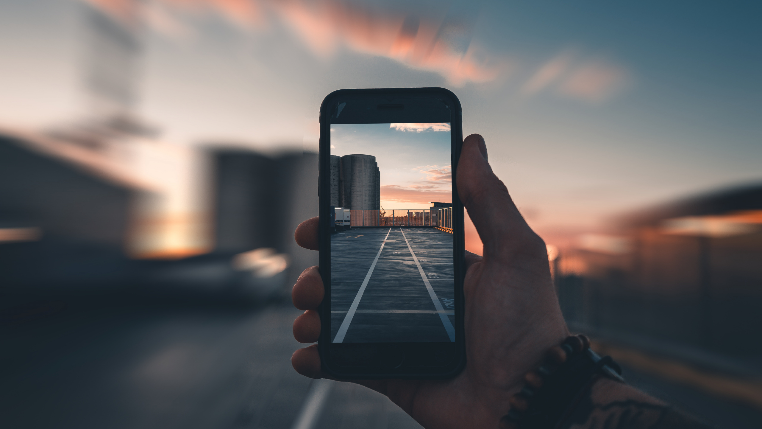 Person Holding Iphone Taking Photo of Sunset. Wallpaper in 2560x1440 Resolution