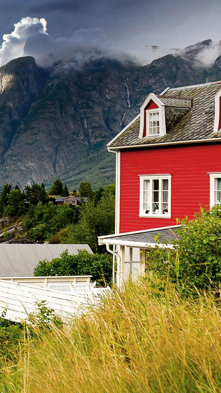 Red and White Wooden House Near Lake and Mountains Under Blue Sky During Daytime. Wallpaper in 750x1334 Resolution