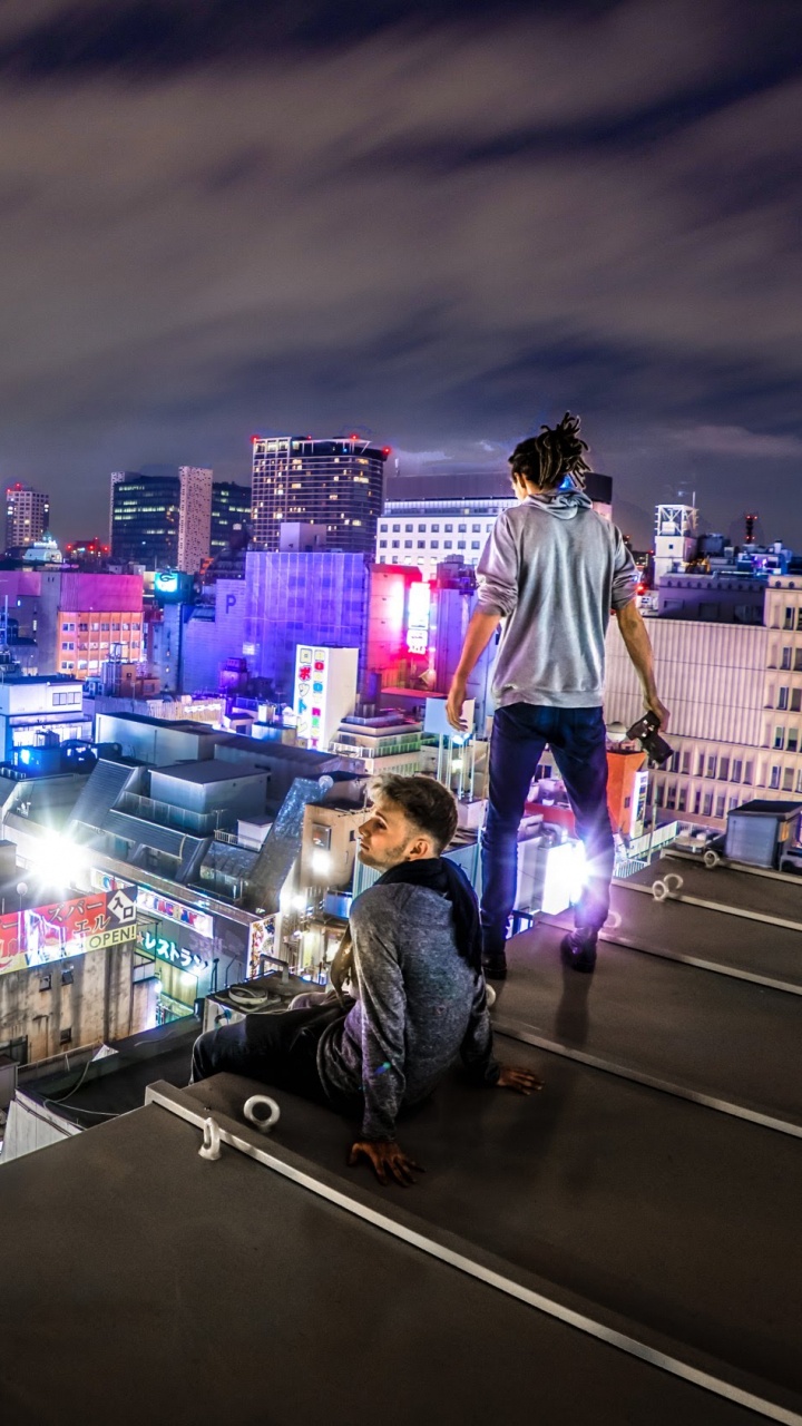 People in a City With Lights Turned on During Night Time. Wallpaper in 720x1280 Resolution