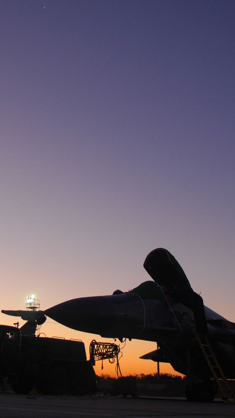 Avion de Chasse Noir et Jaune Dans le Ciel Pendant la Nuit. Wallpaper in 750x1334 Resolution