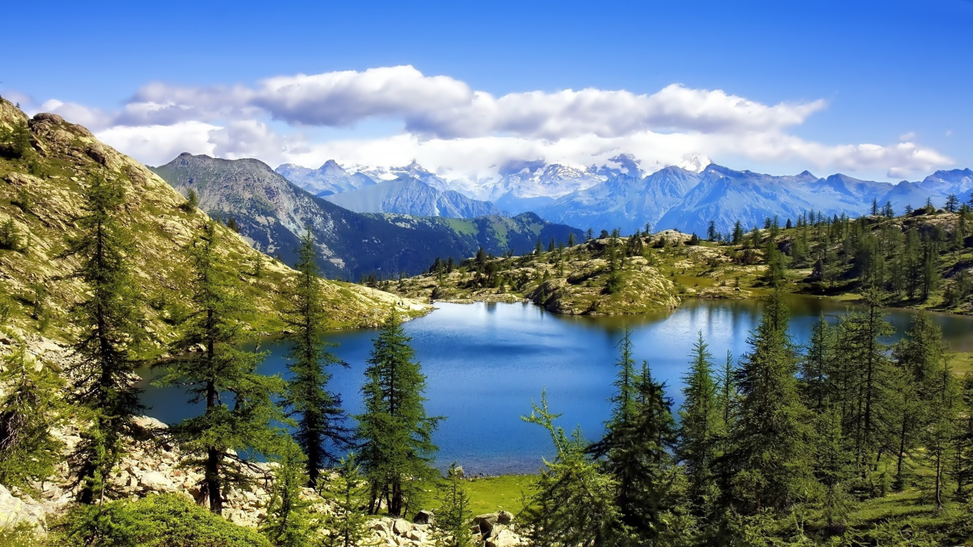 Green Trees Near Lake and Mountains During Daytime. Wallpaper in 1366x768 Resolution