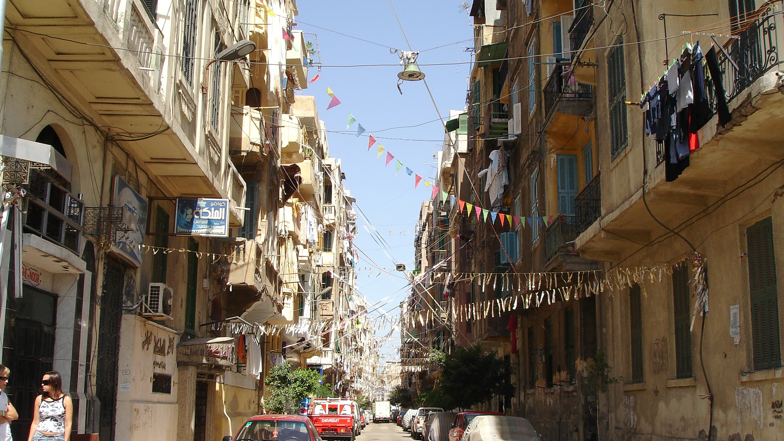 Red Car Parked Beside Gray Concrete Building During Daytime. Wallpaper in 2560x1440 Resolution