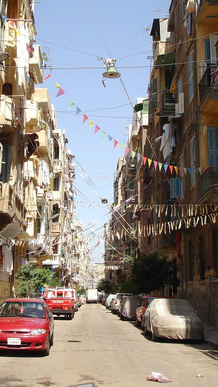 Red Car Parked Beside Gray Concrete Building During Daytime. Wallpaper in 720x1280 Resolution