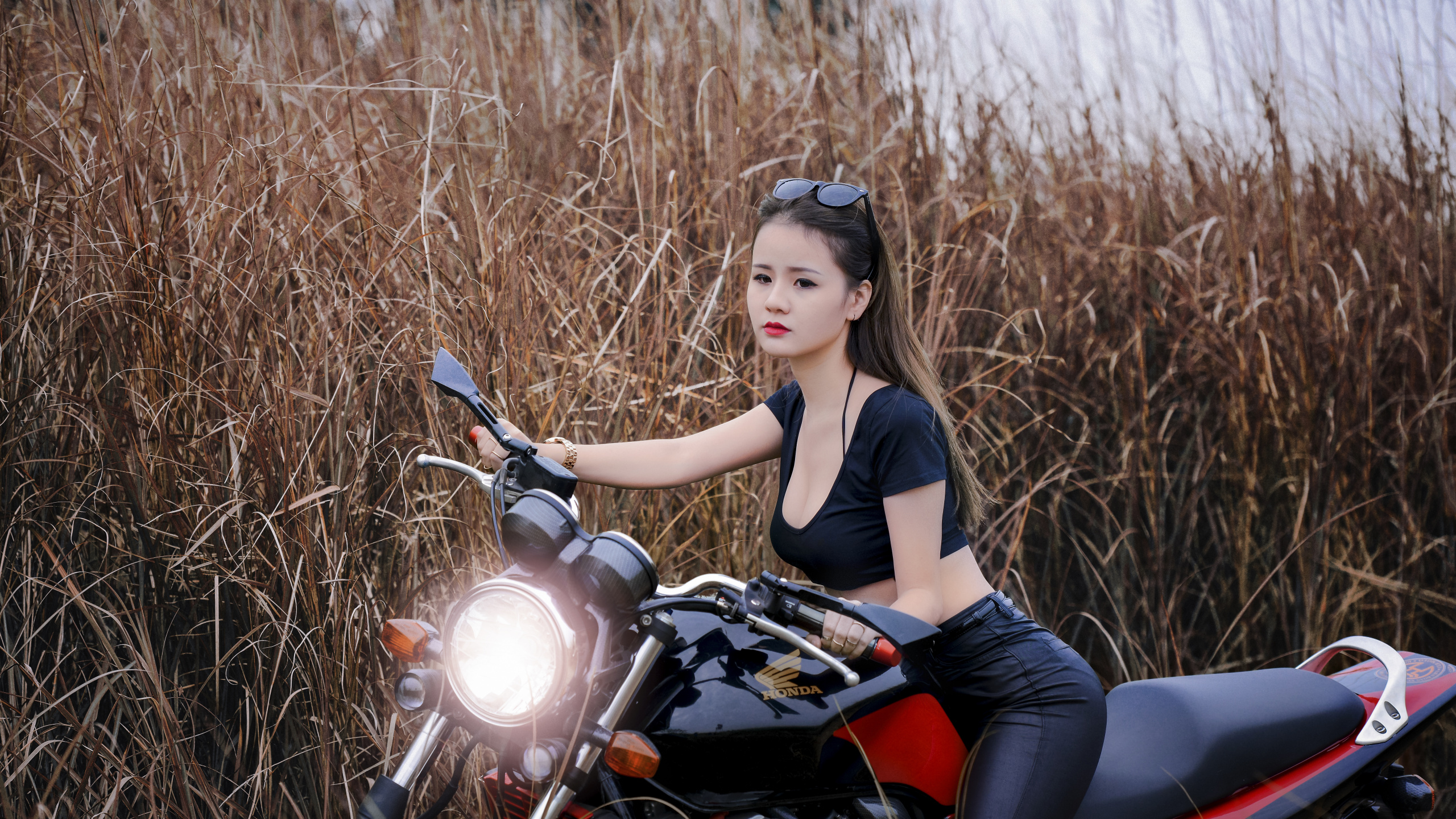 Frau im Schwarzen Tanktop Und Schwarzen Leggings Sitzt Auf Einem Roten Und Schwarzen Motorrad. Wallpaper in 2560x1440 Resolution