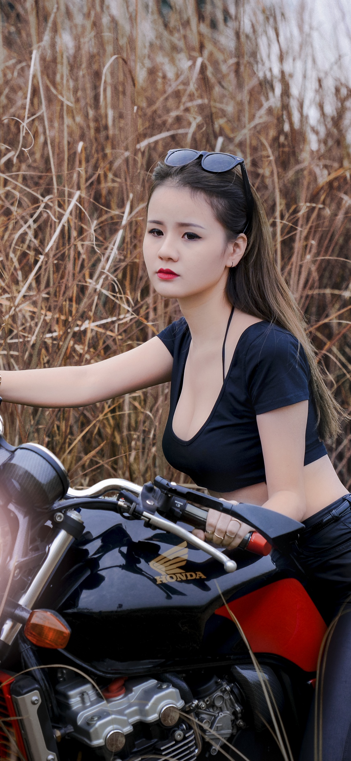 Woman in Black Tank Top and Black Leggings Sitting on Red and Black Motorcycle. Wallpaper in 1125x2436 Resolution