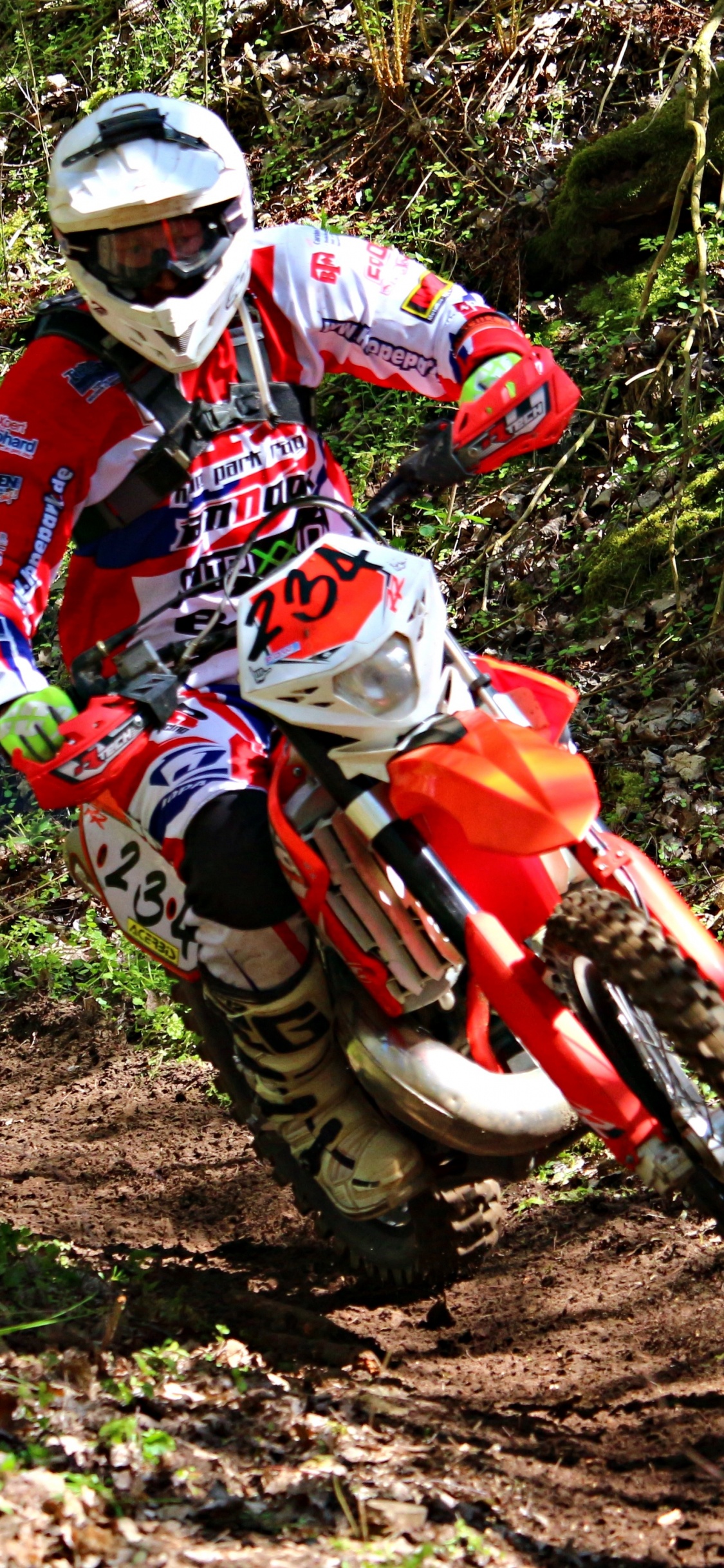 Man in Red and White Motocross Suit Riding Motocross Dirt Bike. Wallpaper in 1125x2436 Resolution