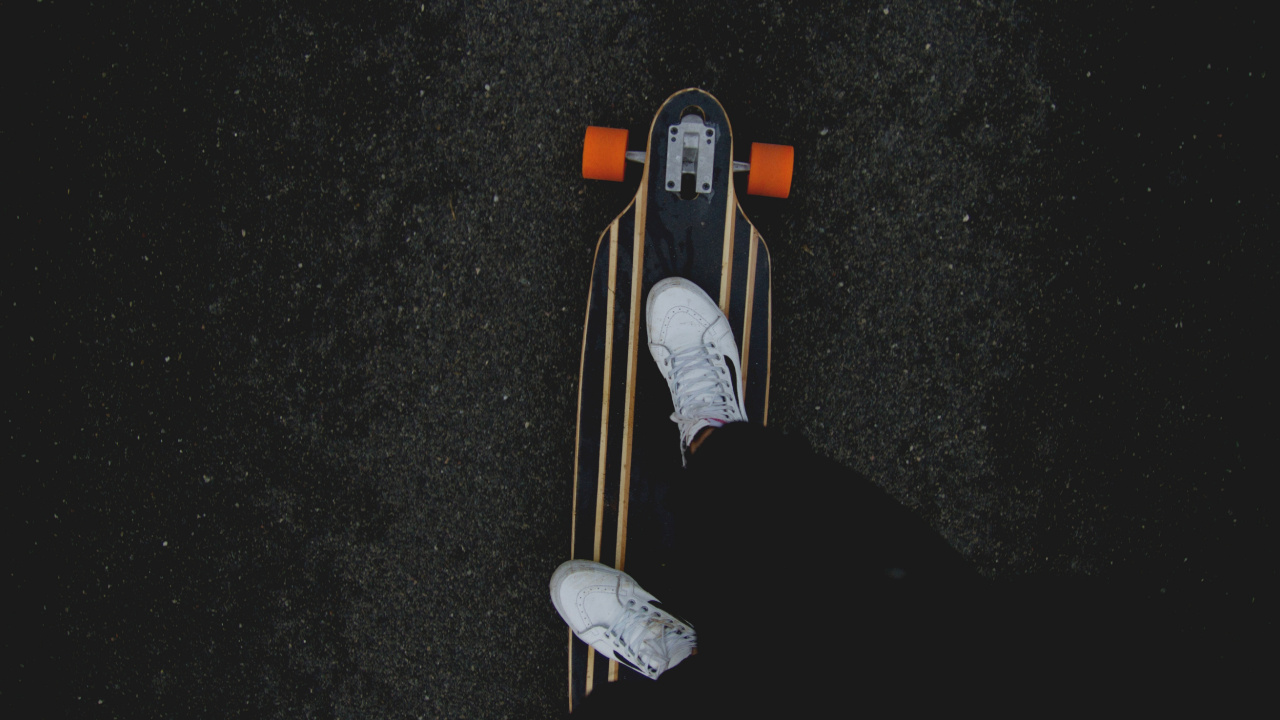 Person in Black Pants and White Sneakers Riding on Brown Wooden Skateboard. Wallpaper in 1280x720 Resolution