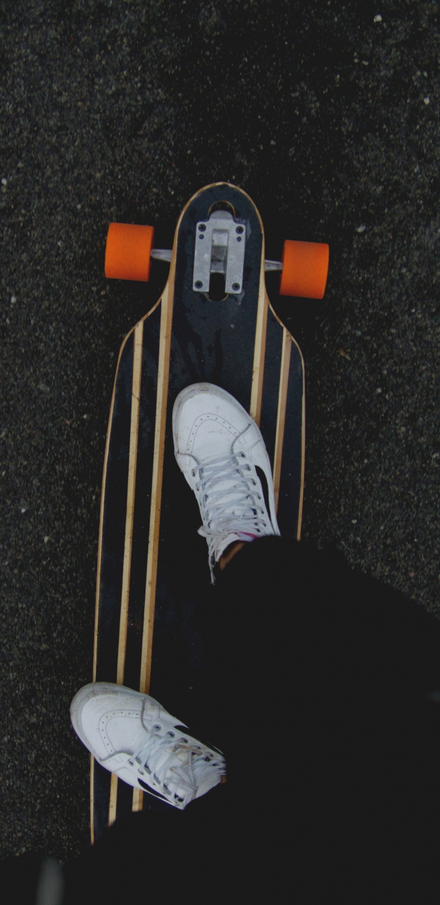 Person in Black Pants and White Sneakers Riding on Brown Wooden Skateboard. Wallpaper in 1440x2960 Resolution
