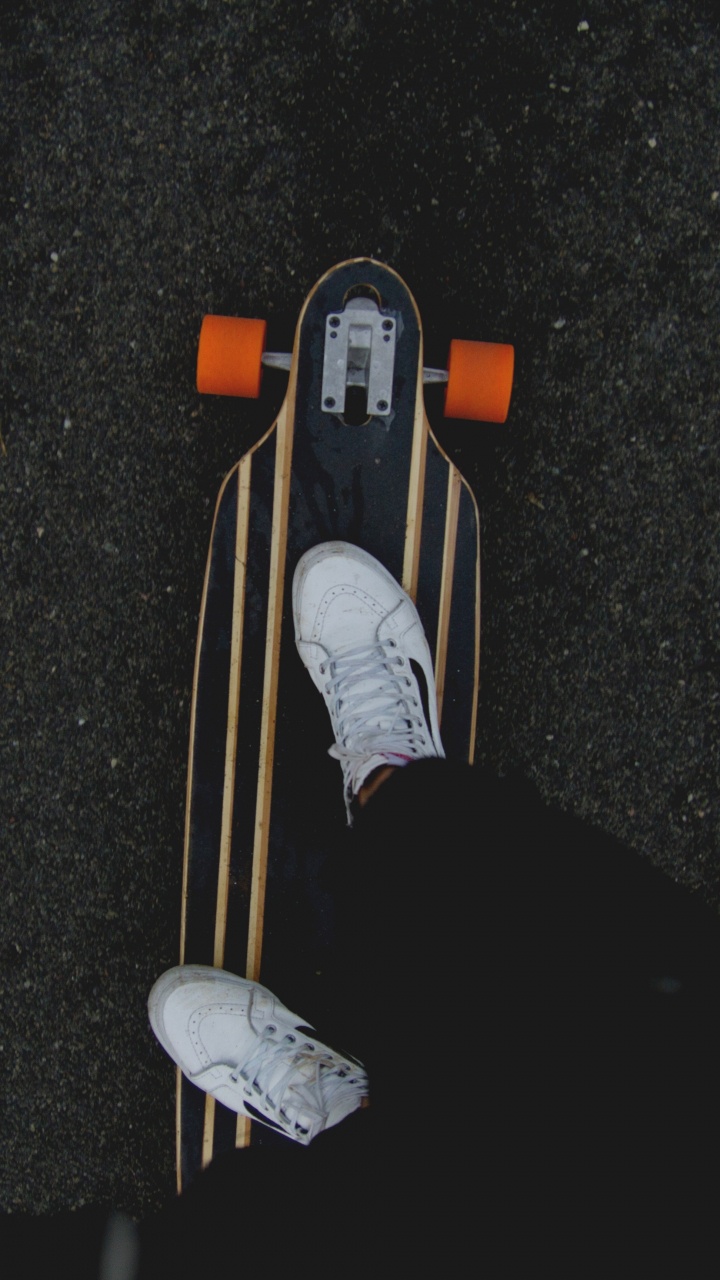 Person in Black Pants and White Sneakers Riding on Brown Wooden Skateboard. Wallpaper in 720x1280 Resolution