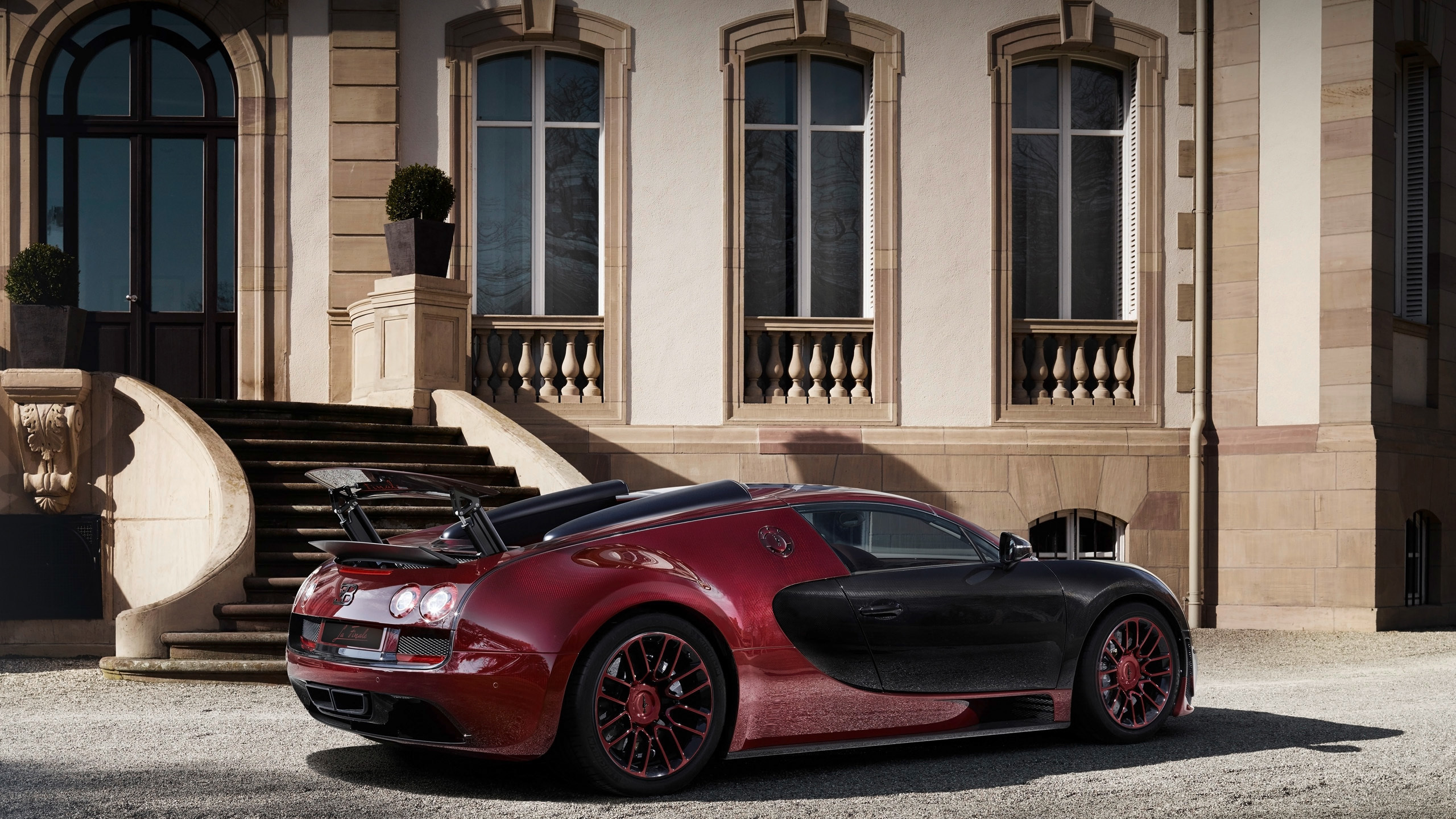 Red Ferrari 458 Italia Parked in Front of Brown Building. Wallpaper in 2560x1440 Resolution