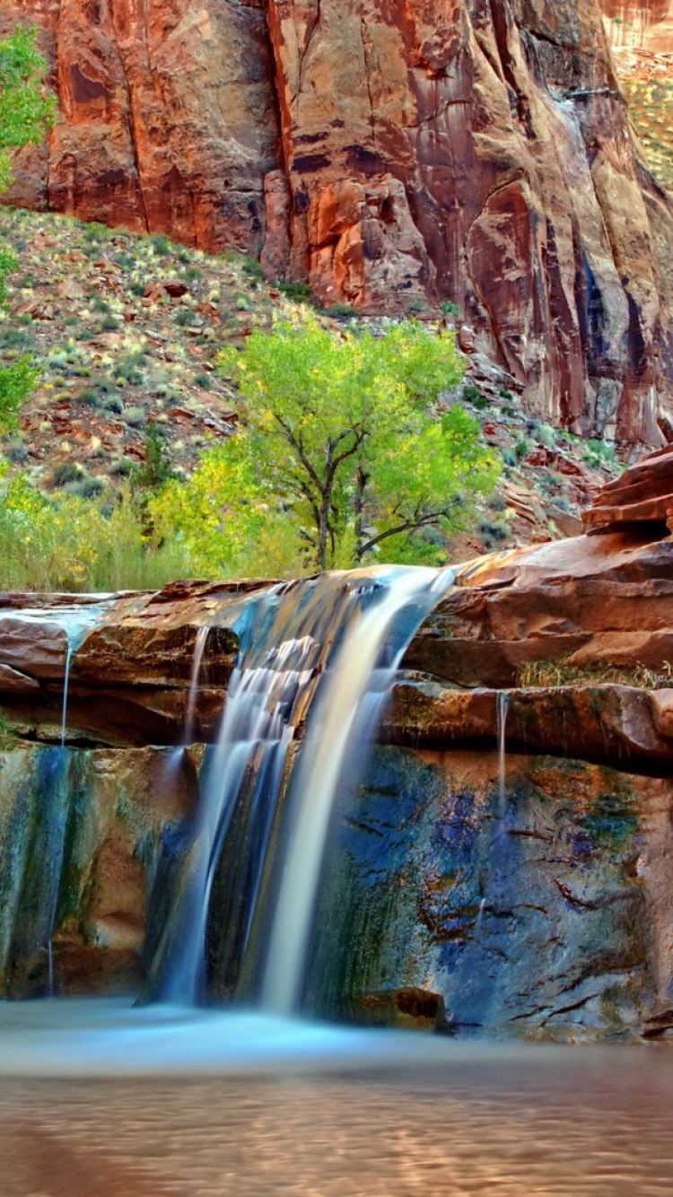 Water Falls in The Middle of Brown Rocky Mountain. Wallpaper in 750x1334 Resolution