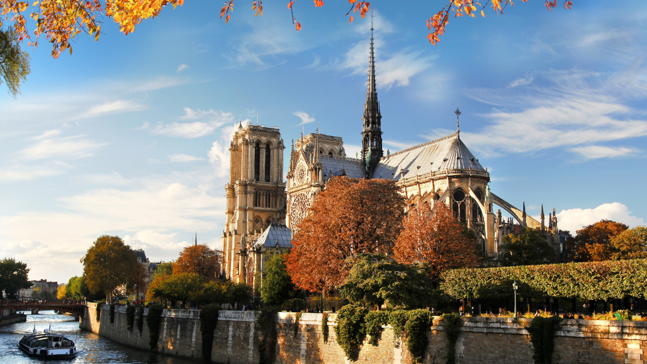 Brown Concrete Building Near River Under Blue Sky During Daytime. Wallpaper in 1280x720 Resolution