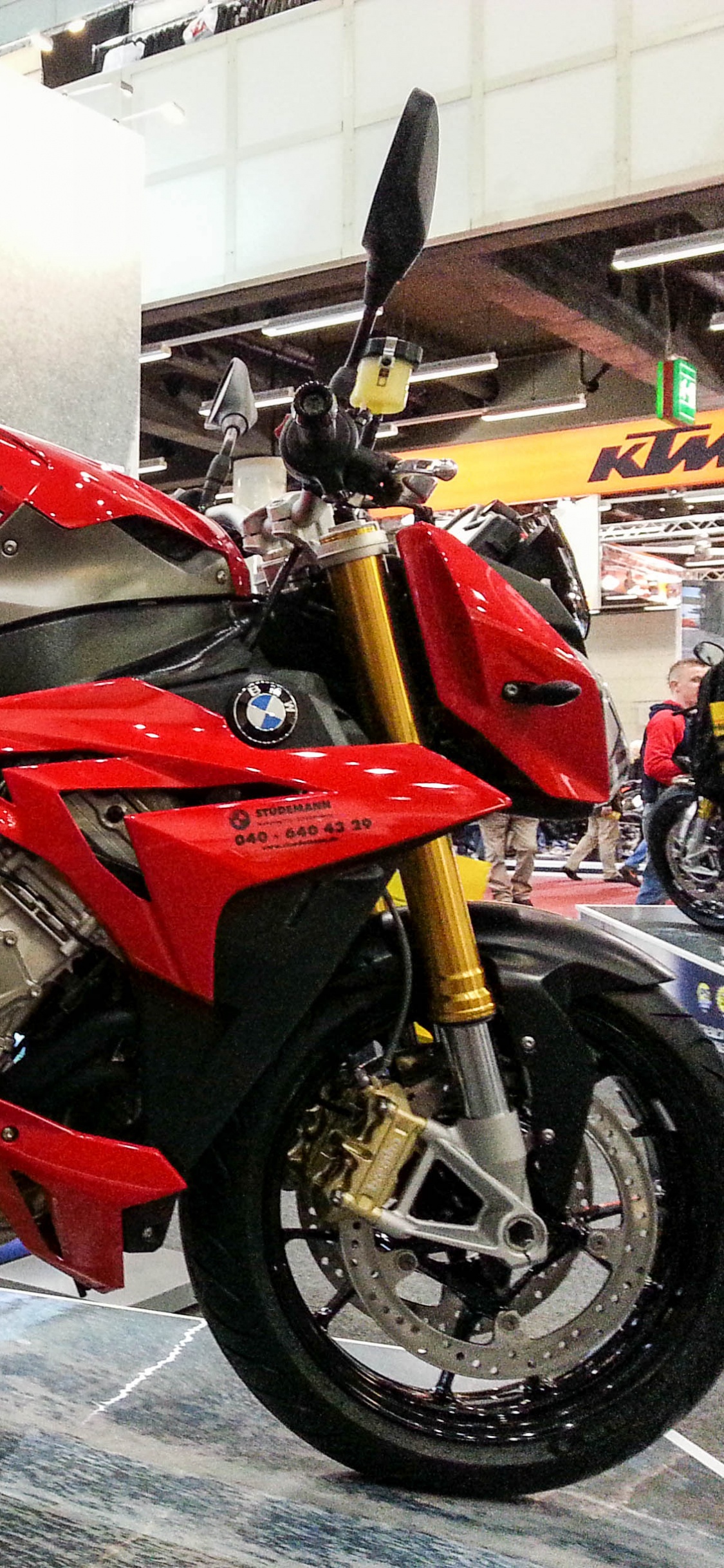 Red and Black Sports Bike Parked Beside White Wall. Wallpaper in 1125x2436 Resolution