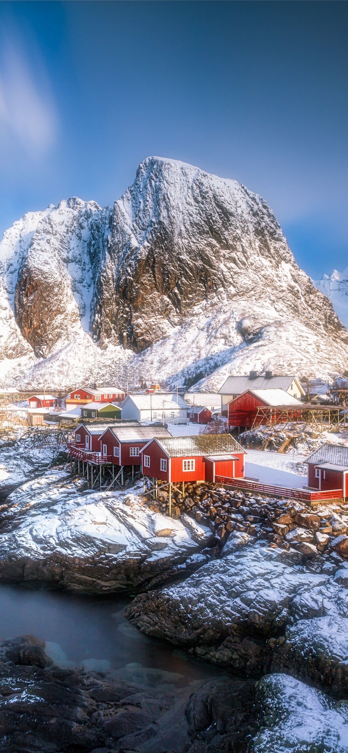 White and Brown House Near Body of Water and Mountain Under Blue Sky During Daytime. Wallpaper in 1125x2436 Resolution