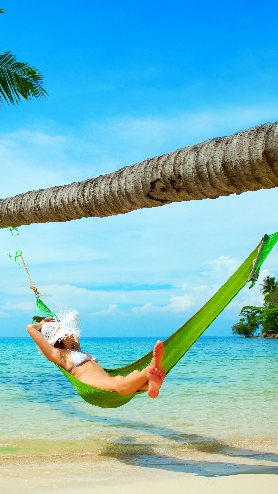 Woman in White Shirt and Green Shorts Lying on Hammock Under Coconut Tree During Daytime. Wallpaper in 1080x1920 Resolution